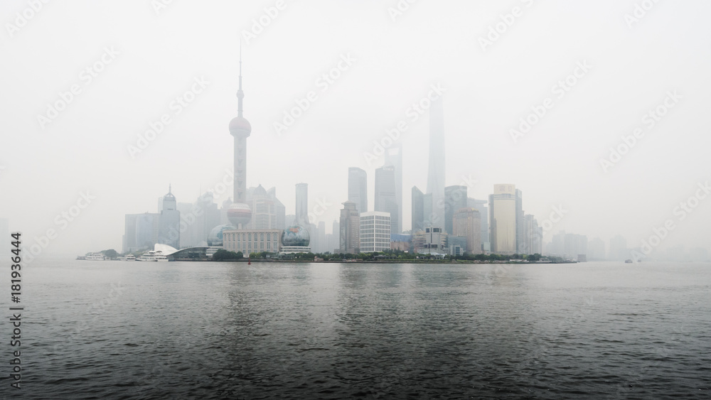 View of Shanghai business district skyline across the Huangpu river, with pollution mist.