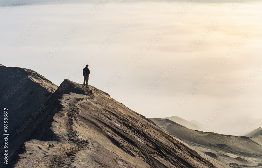 Man looking at sea of clouds on top of a mountain crest