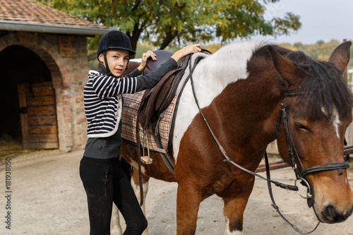 Ready for riding!- A young girl is preparing to get rid of a horse © cherryandbees