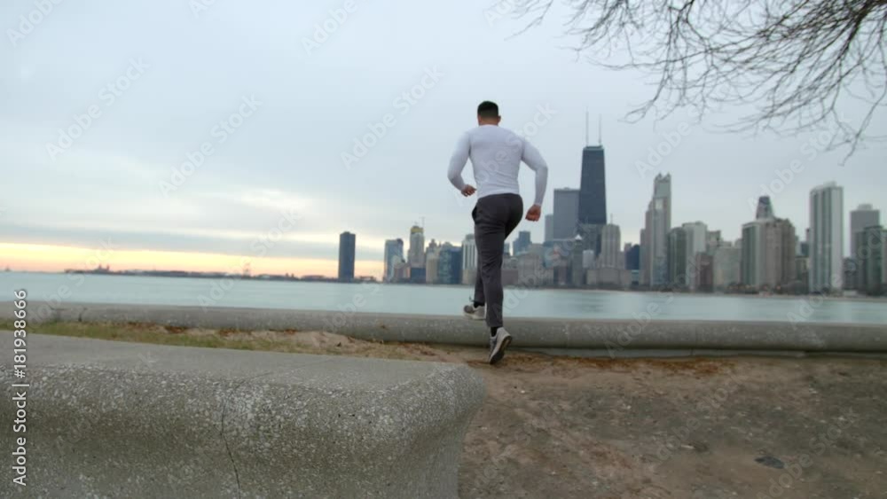 Athletic man with fit muscular body is climbing on the embankment after the jogging on the beach. Stops and taking a look at the sea. Sunrise. Finishing of the morning exersises. Athletic man with fit muscular body is climbing on the embankment after the jogging on the beach. Stops and taking a look at the sea. Sunrise. Finishing of the morning exersises.