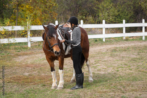 Ready for riding! - A young girl checks the saddle of a horse © cherryandbees