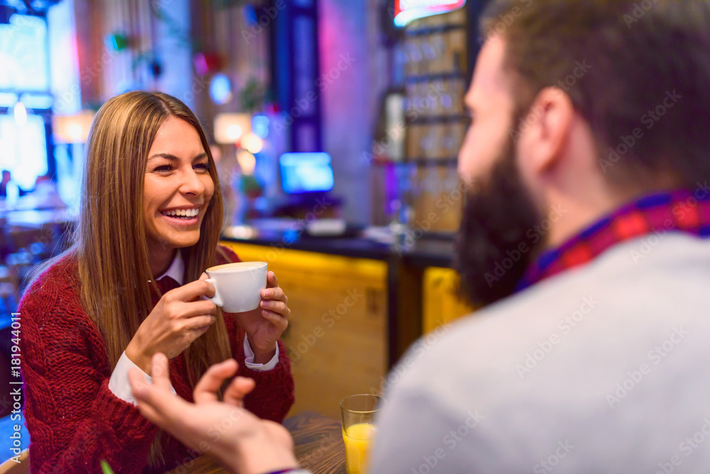 Beautiful couple drinking coffee talking and having fun in cafeteria Beautiful couple drinking coffee talking and having fun in cafeteria
