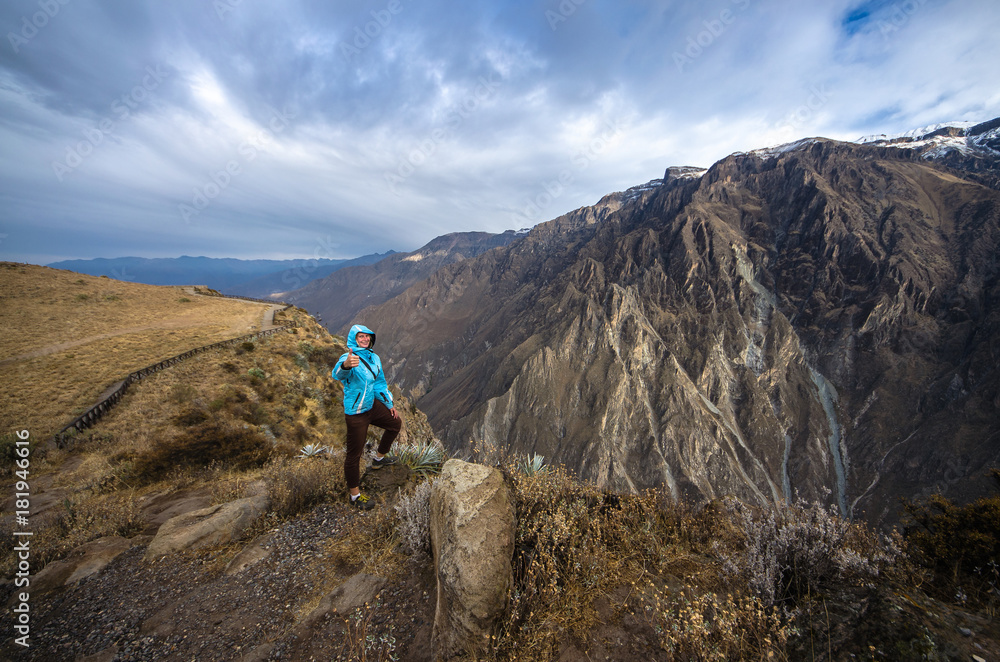 Young woman meditate above the deepest canyon Colca. Panoramic breathtaking view of peruvian village and canyon Colca , Peru, South America