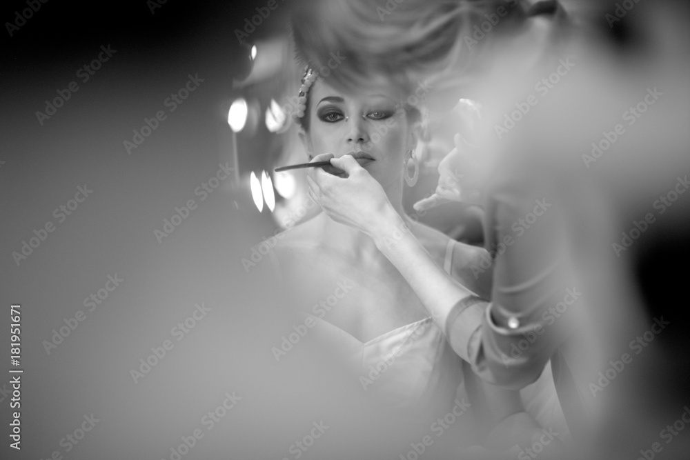 Fototapeta premium Drawing a stage makeup on the face of a ballerina before the performance