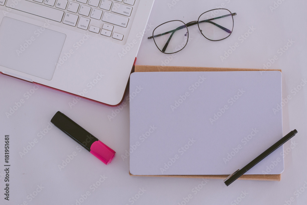Working desk with blank white paper poster mock up and computer Working desk with blank white paper poster mock up and computer