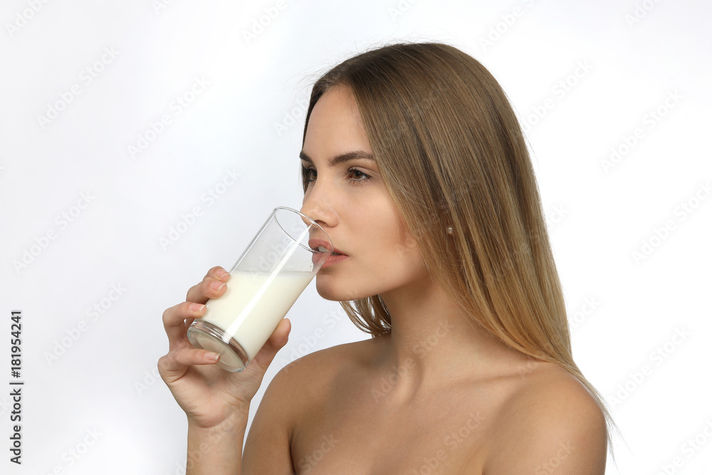 Hübsche blonde Frau mit nackten Schultern und einem Glas Milch lacht Hübsche blonde Frau mit nackten Schultern und einem Glas Milch lacht