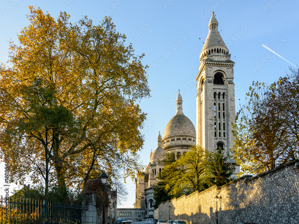 Naklejka premium Back view of the Basilica of the Sacred Heart of Paris at sunrise in autumn with the square steeple in the foreground.