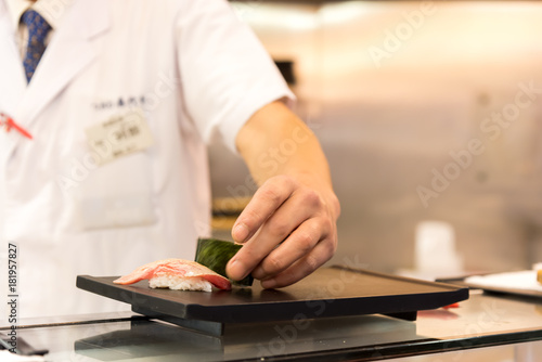 Chef making Sushi on the plate in a Japanese restaurant.