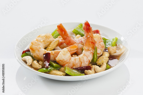 cajun Shrimps with cashew nuts stir fry vegetables on white plate with white background 