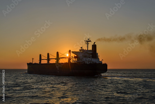 Bulker cargo vessel at sunset