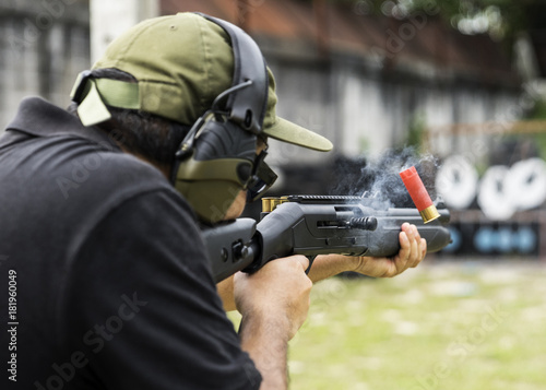 Man shooting on an outdoor shooting range, selective focus photo
