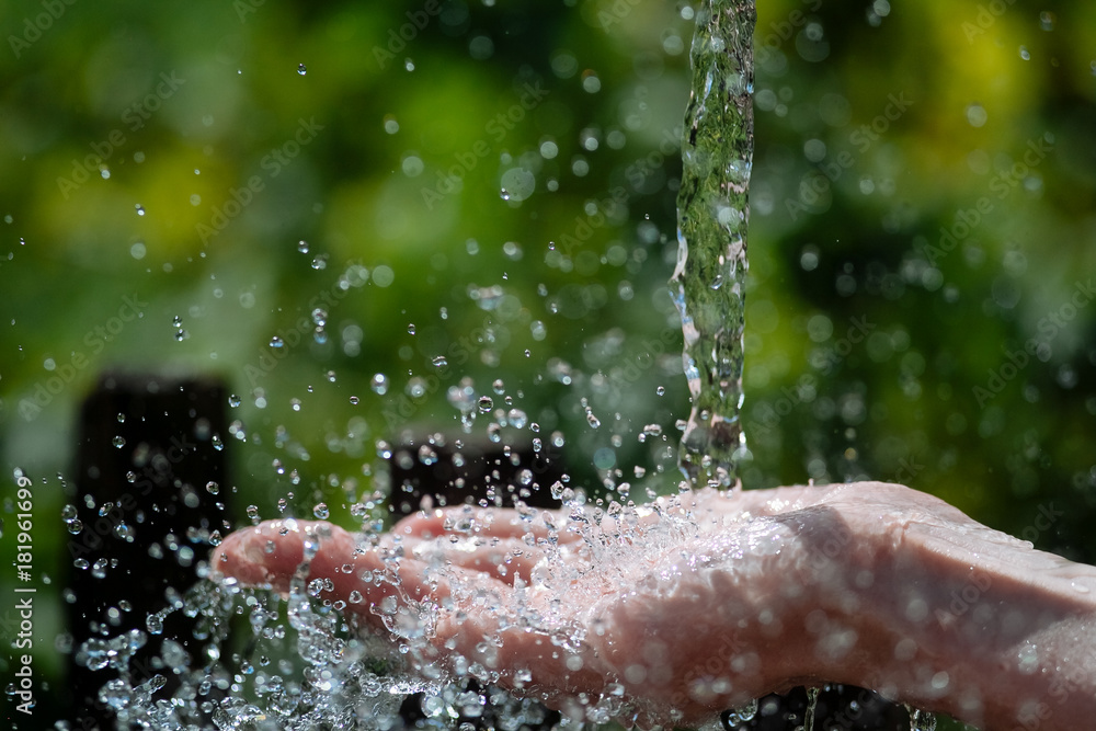 Fototapeta premium A spray of water on a woman's hand.