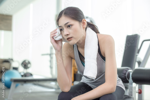 Beautiful Asian Woman resting when finish to exercise at Gym, Woman Exercise Concept.