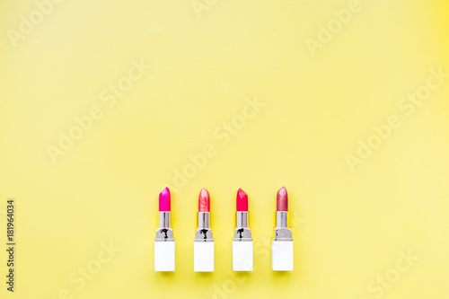 Lipsticks assorted colors on yellow background top view copyspace © 9dreamstudio