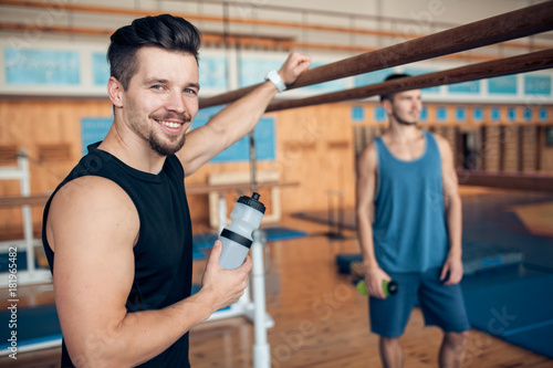 two smiling guys in oldschool wooden gym;