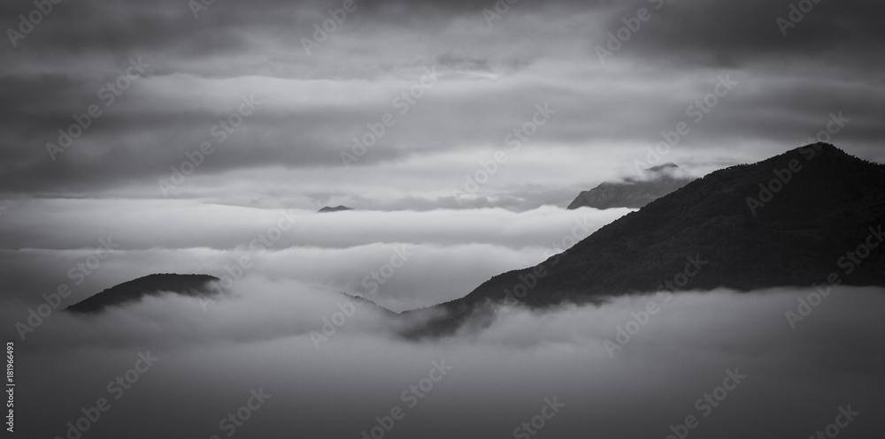 view of a sea of ​​clouds at sunrise, the valleys are covered with mist 
