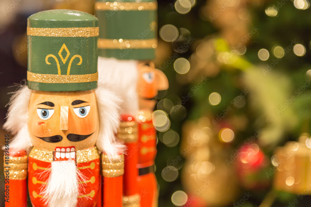 Soldier nutcracker statues standing in front of decorated Christmas tree with bokeh lights Soldier nutcracker statues standing in front of decorated Christmas tree with bokeh lights
