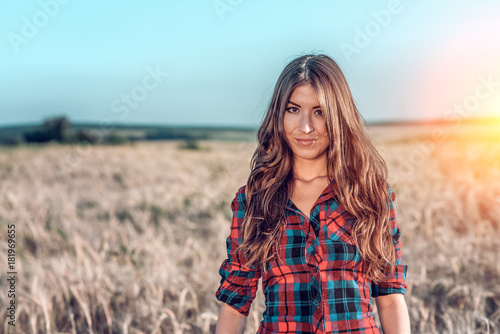 Beautiful happy girl in the field, sunny afternoon, shorts shirt. The concept of enjoying nature. Rest on the air. Walking through the meadows in wheat in the summer. Beautiful hair Happy smiling