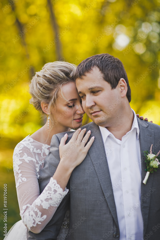 Fototapeta premium The bride hugs the groom on the background of a Sunny forest 50.