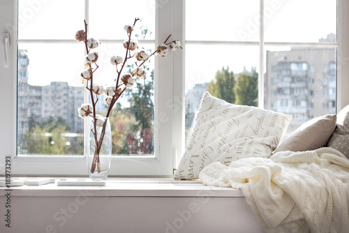 cushions and a knitted plaid on the windowsill.
