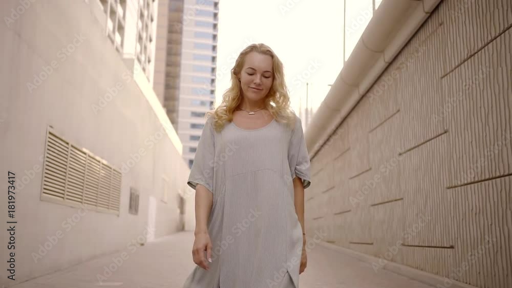magnificent adult woman is strolling in a tunnel in city street, looking to a camera magnificent adult woman is strolling in a tunnel in city street, looking to a camera