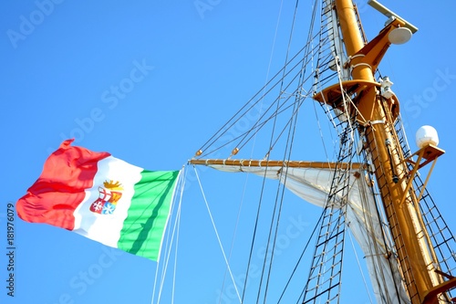 Details of outdoor exterior of an Italian ship with flag and blue sky photo