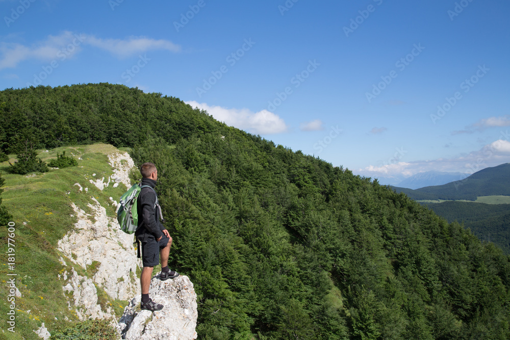 Hiker stands on mountain slope, Vado di Sole, National Park Gran Sasso and Monti della Laga, summer 