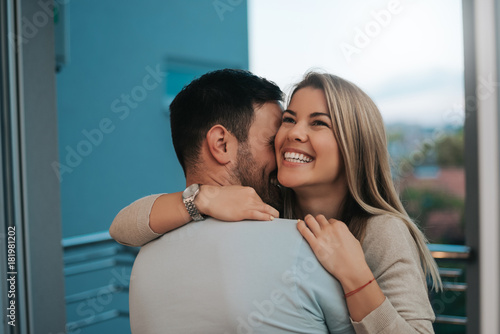 Beautiful lady leans to man's shoulder while he hugs her.