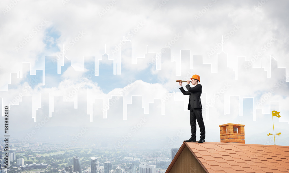 Engineer man standing on roof and looking in spyglass. Mixed media Engineer man standing on roof and looking in spyglass. Mixed media