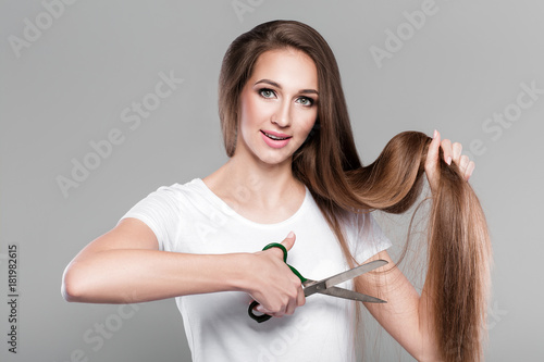 woman with long hair holds scissors 