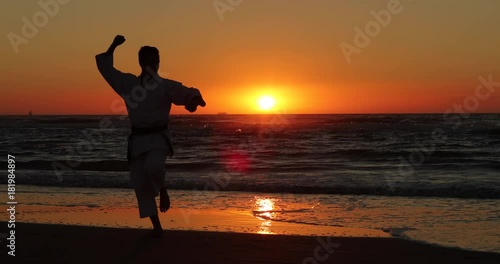 Silhouetted karate kata on the beach by a teenager