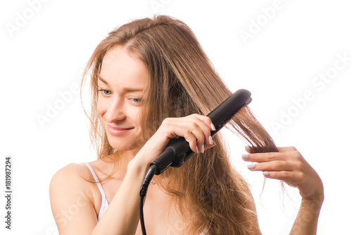 Beautiful young woman hair ironing
