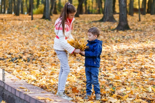 A happy family having fun in the park in autumn walking and hugging. Family, love, happiness concept. sister and a little cute brother hugging