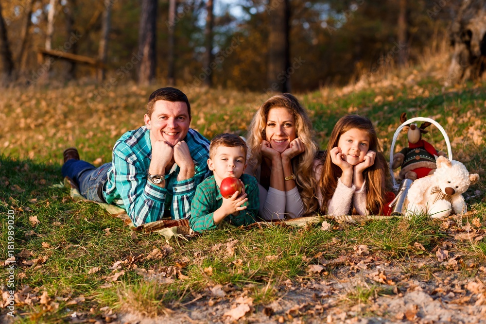 A happy family having fun in the park in autumn. Family, love, happiness concept. Family of four A happy family having fun in the park in autumn. Family, love, happiness concept. Family of four