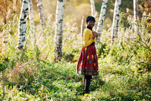 African american girl at yellow and red dress at golden autumn fall park. © AS Photo Family