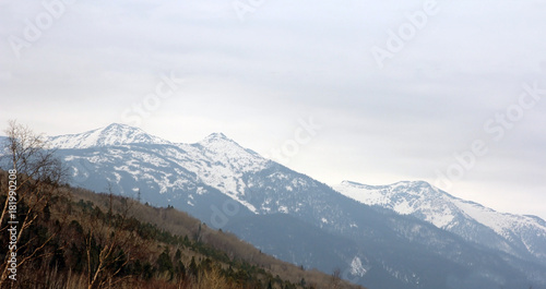 Mountain ridges covered with snow and overcast sky.