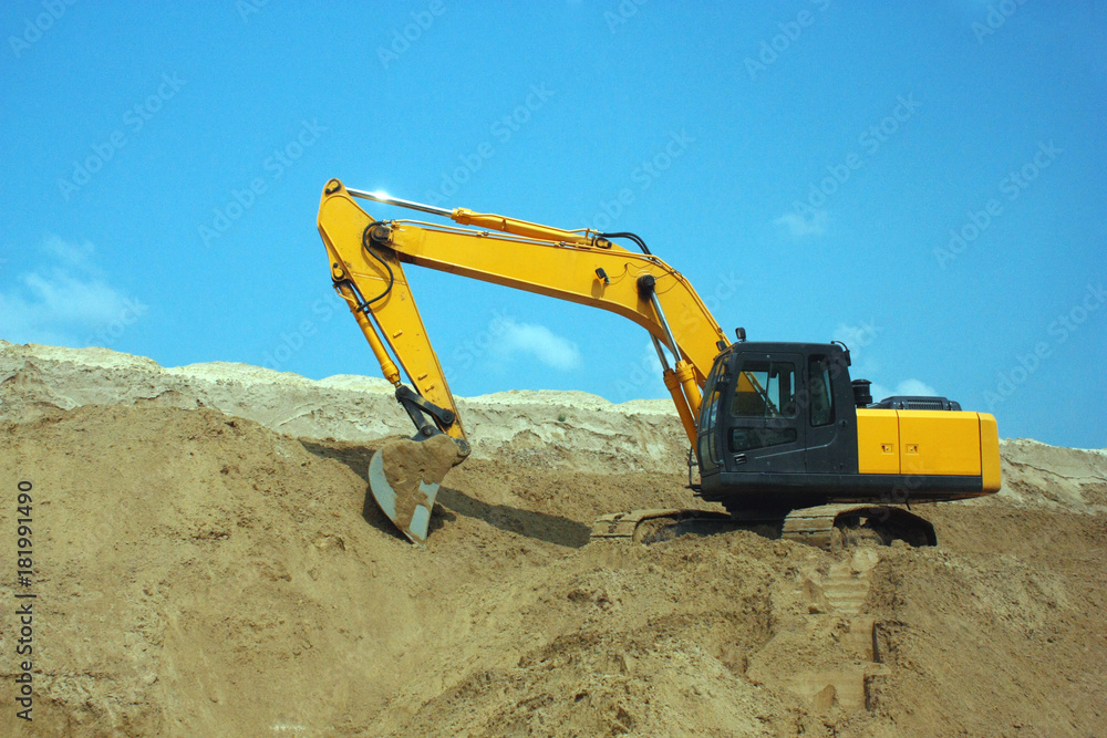 Yellow excavator, excavation work at a construction site. Yellow excavator, excavation work at a construction site.