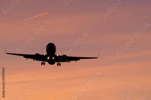 plane will land in orange air and a other plane in the background