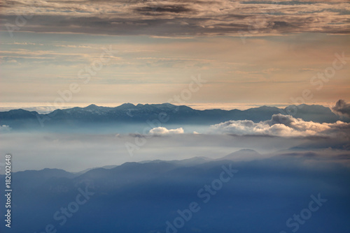 Mountain ridge silhouettes in glowing autumn mist and sea of clouds, South / Lower Bohinj Range, Sava valley and Pokljuka plateau, Julian Alps, Triglav National Park Gorenjska Kranjska Slovenia Europe