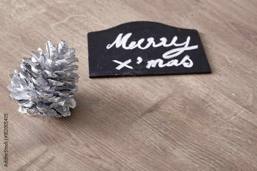 merry christmas text sign with pine cone ornament