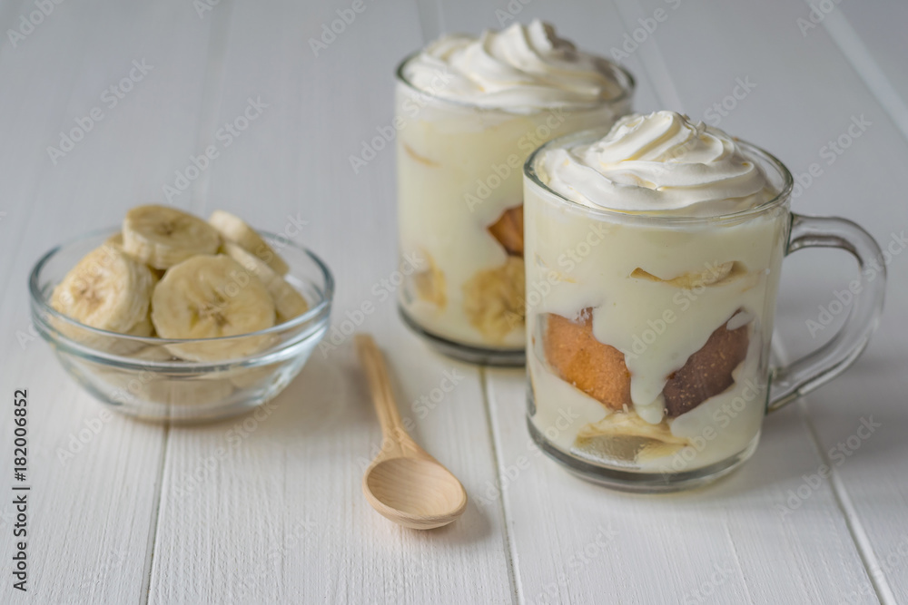 Banana dessert with whipped cream and biscuit on a white table. Banana dessert with whipped cream and biscuit on a white table.