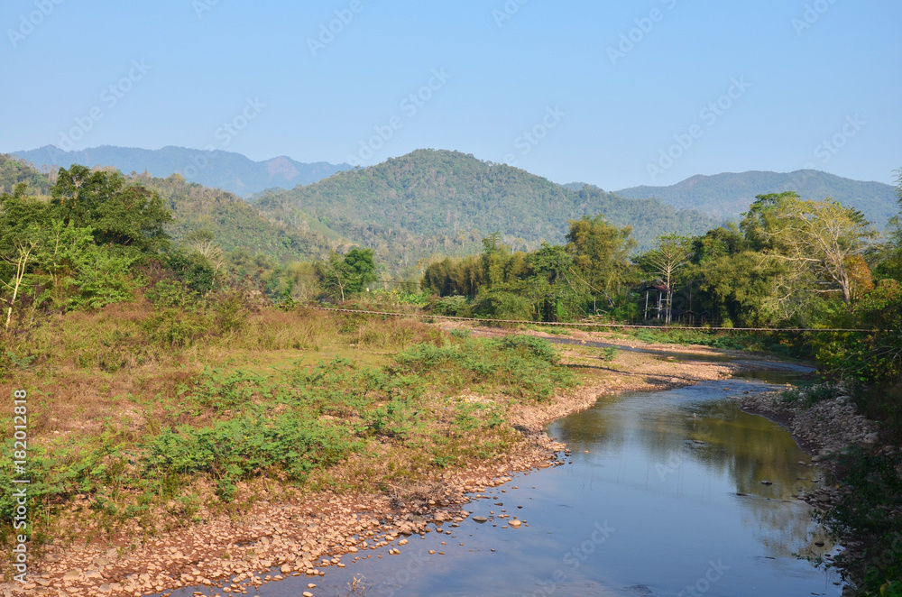 Landscape of forest and mountain with stream in morning time at Ban Bo Kluea village of Nan, Thailand