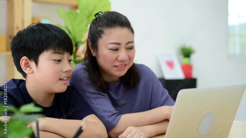 Mother and son laughing while looking computer laptop. Mother and son laughing while looking computer laptop.