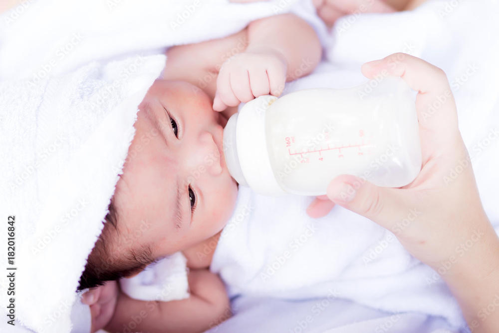 Closeup portrait of mother feeding newborn baby by milk bottle Closeup portrait of mother feeding newborn baby by milk bottle