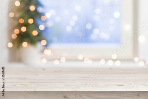 Empty wooden table in front of blurred winter holiday background photo