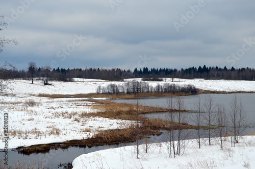 bright white snow melts  calm not frozen river  landscape