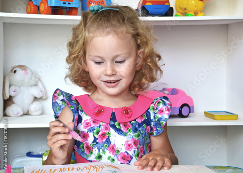 A little girl is drawing in the children's room.