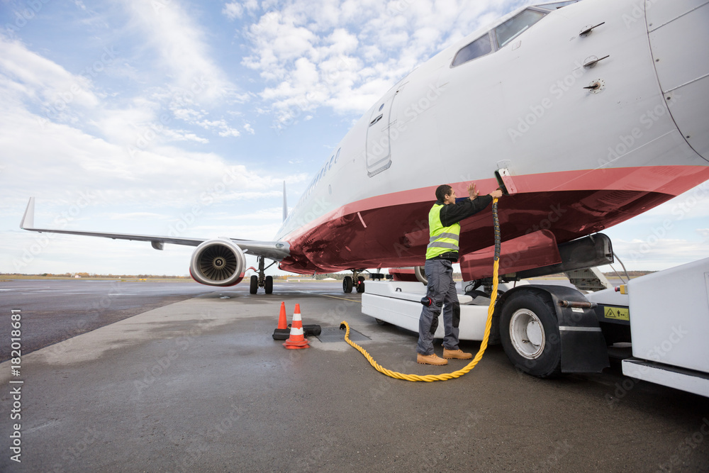 Full Length Of Crew Member Charging Airplane Full Length Of Crew Member Charging Airplane
