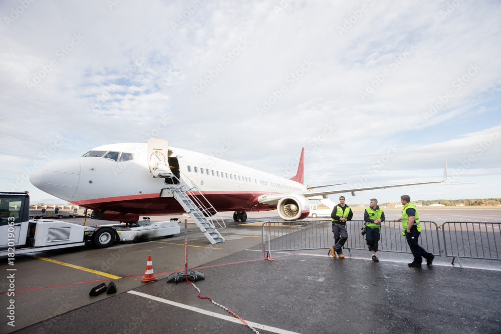 Crew Leaning On Fence While Standing By Airplane Crew Leaning On Fence While Standing By Airplane