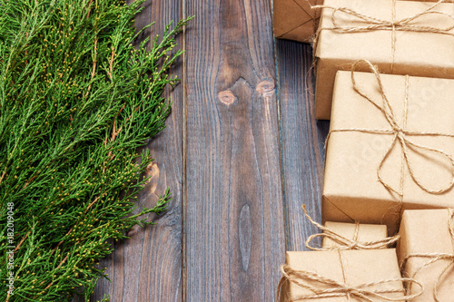 Many gift box on dark rustic wooden background with copy space. Christmas fir tree branches. Christmas conceps photo